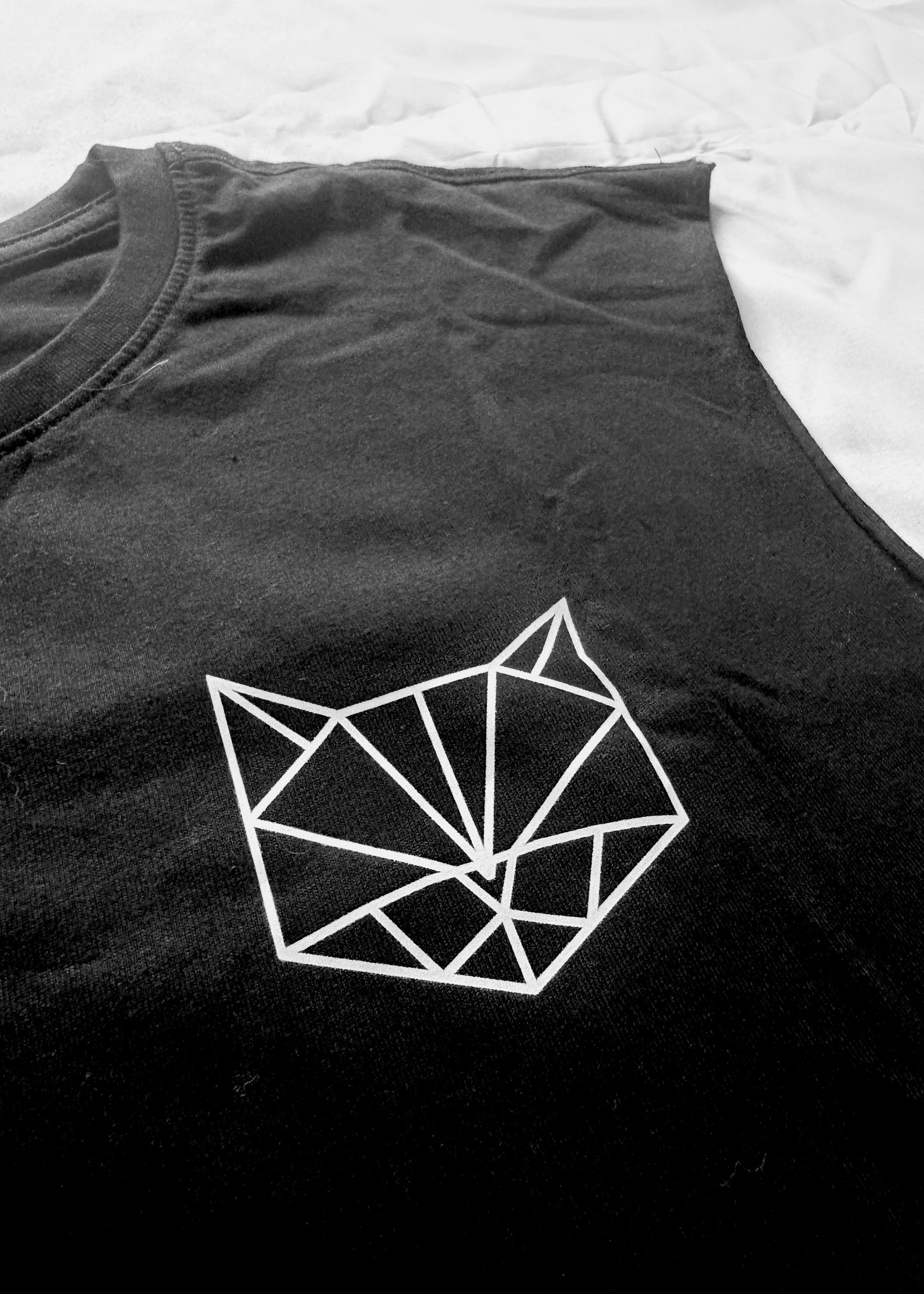 KATERMUKKE Black cotton tank top with a minimalist front featuring a small cat logo on the chest and a hand-sewn PAPAGE label near the hem. The back shows a large geometric cat design printed in white using high-quality screen printing. The fit is oversized with dropped shoulders and a crew neck.