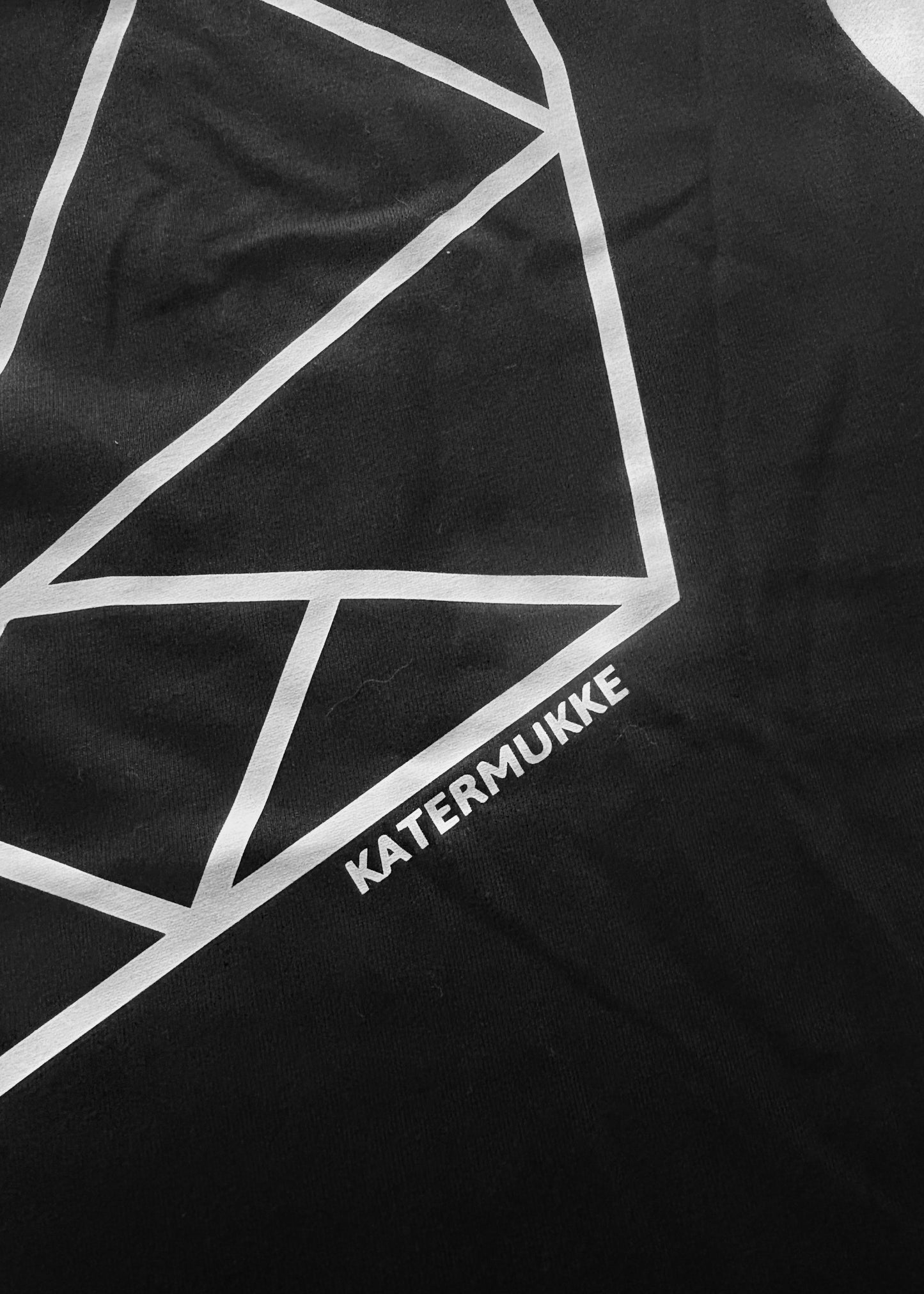 Black cotton tank top with a minimalist front featuring a small cat logo on the chest and a hand-sewn PAPAGE label near the hem. The back shows a large geometric cat design printed in white using high-quality screen printing. The fit is oversized with dropped shoulders and a crew neck.